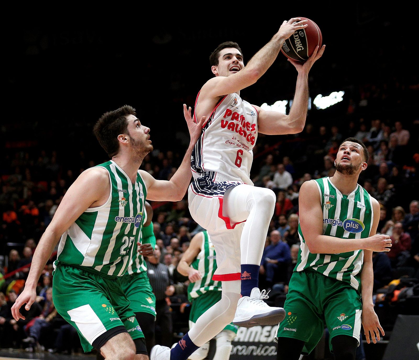 El alero del Valencia Basket, Alberto Abalde (c), lanza a canasta ante los jugadores del Betis.