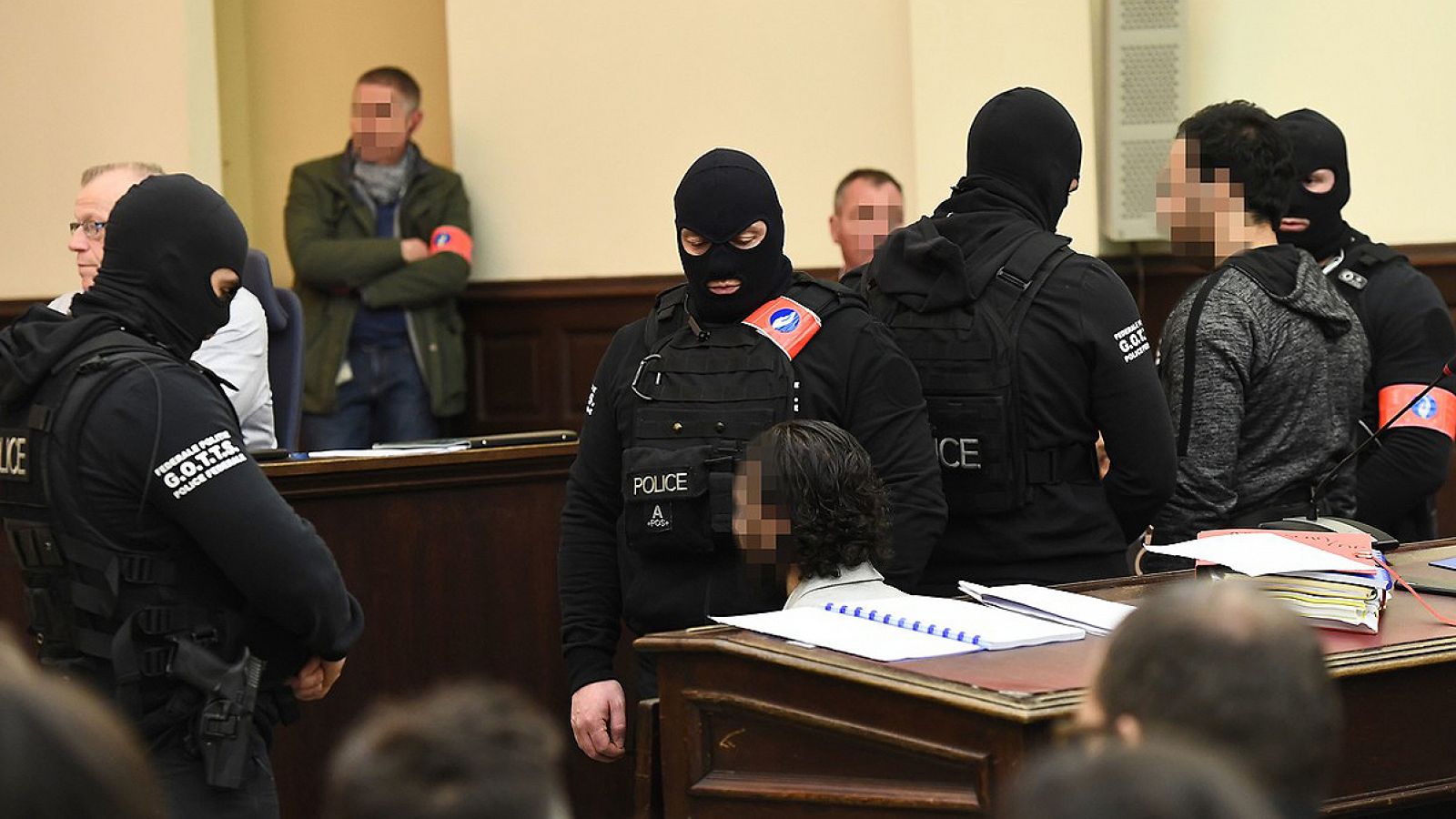 El presunto terrorista Salah Abdeslam (izquierda, sentado y con la cara difuminada) durante el primero de los juicios a los que se enfrenta, en el Palacio de Justicia de Bruselas, Bélgica. El sospechoso en pie es su presunto cómplice, Sofiane Ayari