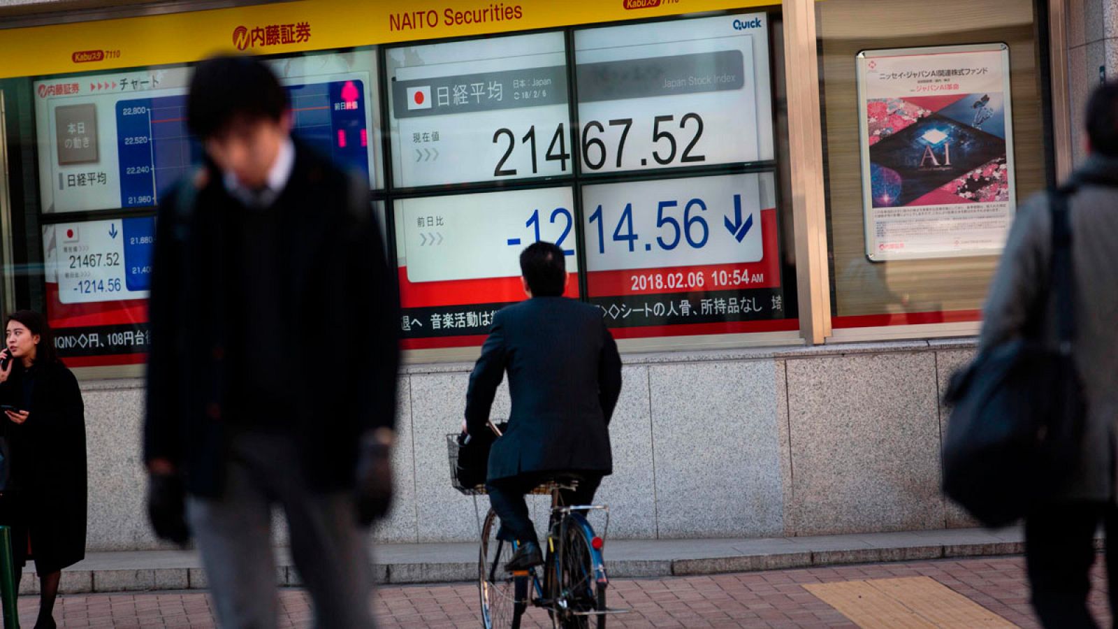 Transeúntes pasan delante de las pantallas electrónicas que muestran la evolución de la Bolsa de Tokio