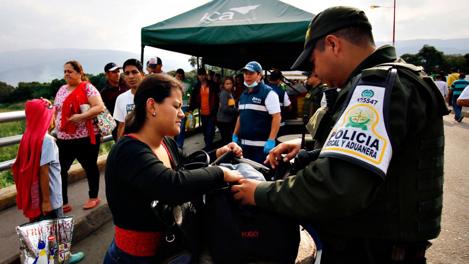 Un guardia fronterizo examina el equipaje de una mujer en el puente internacional Simón Bolívar, la frontera entre Colombia y Venezuela