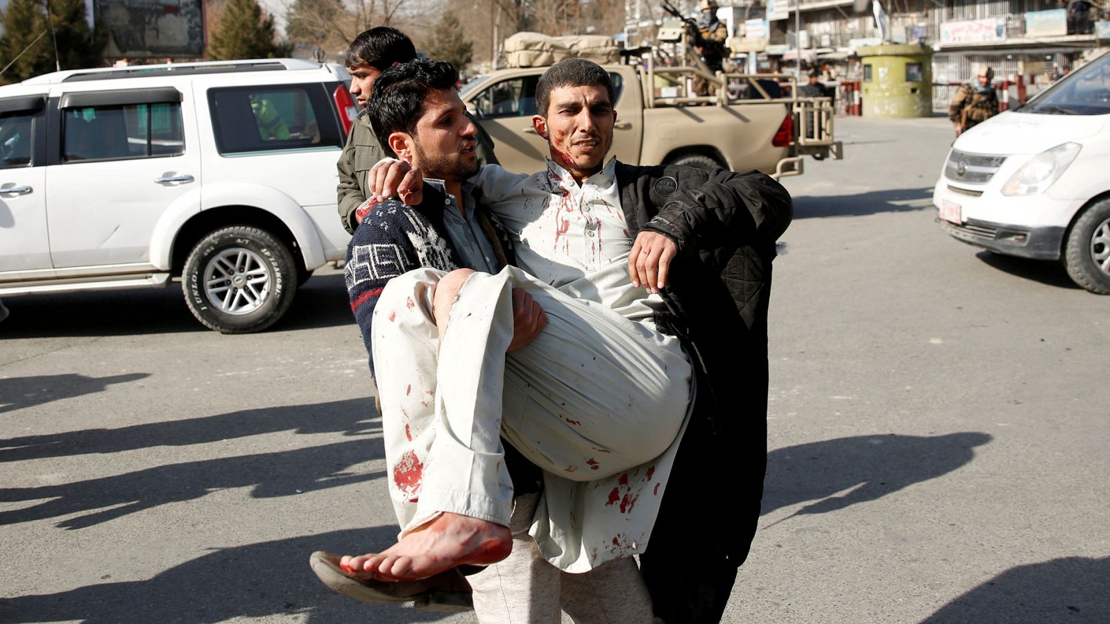 Un hombre acarrea a un herido por una explosión en Kabuil, Afganistán