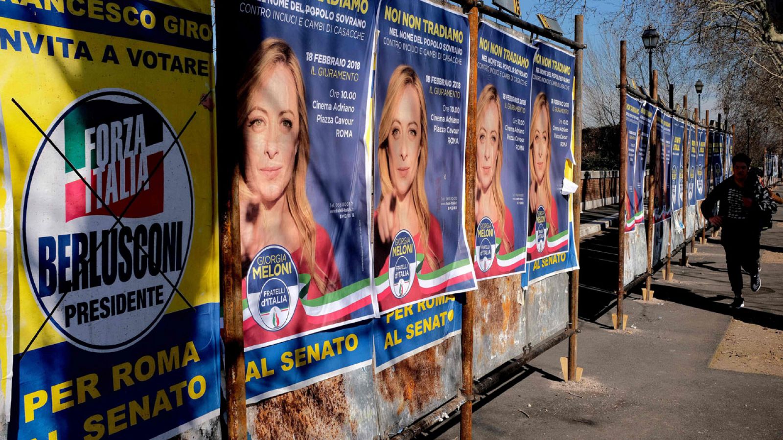 Un hombre pasea por una calle con carteles electorales en Roma