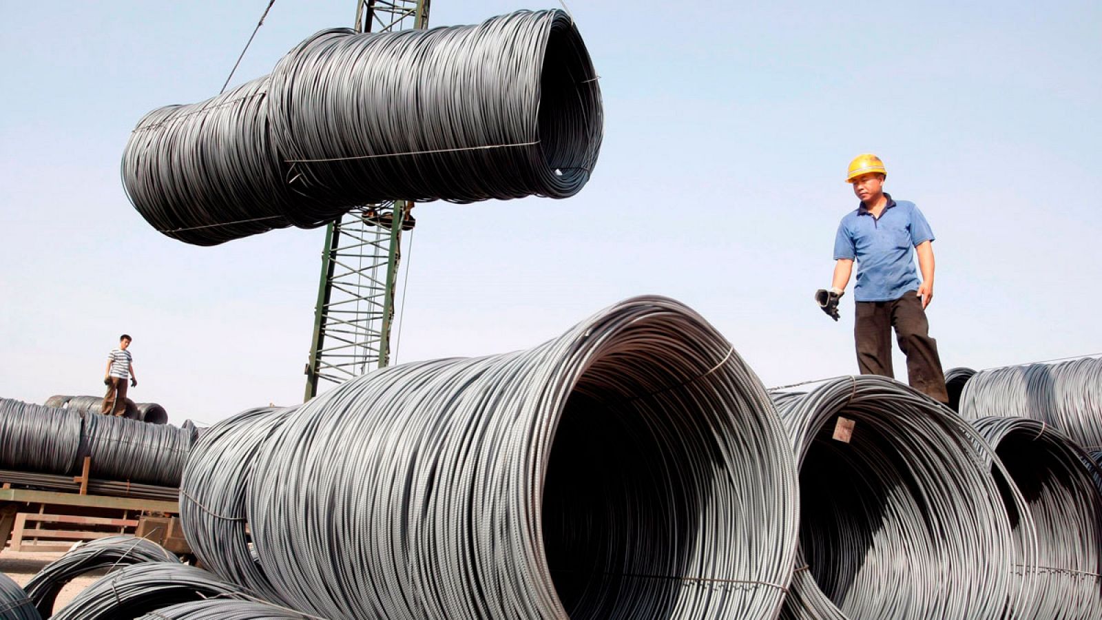 Operarios mientras transportan bobinas de cable de acero para su pesaje en Pekín (China)
