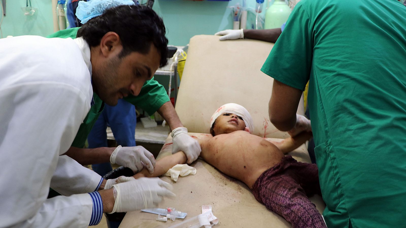 Médicos yemeníes ateinden a un niño herido tras un bombardeo en Saada