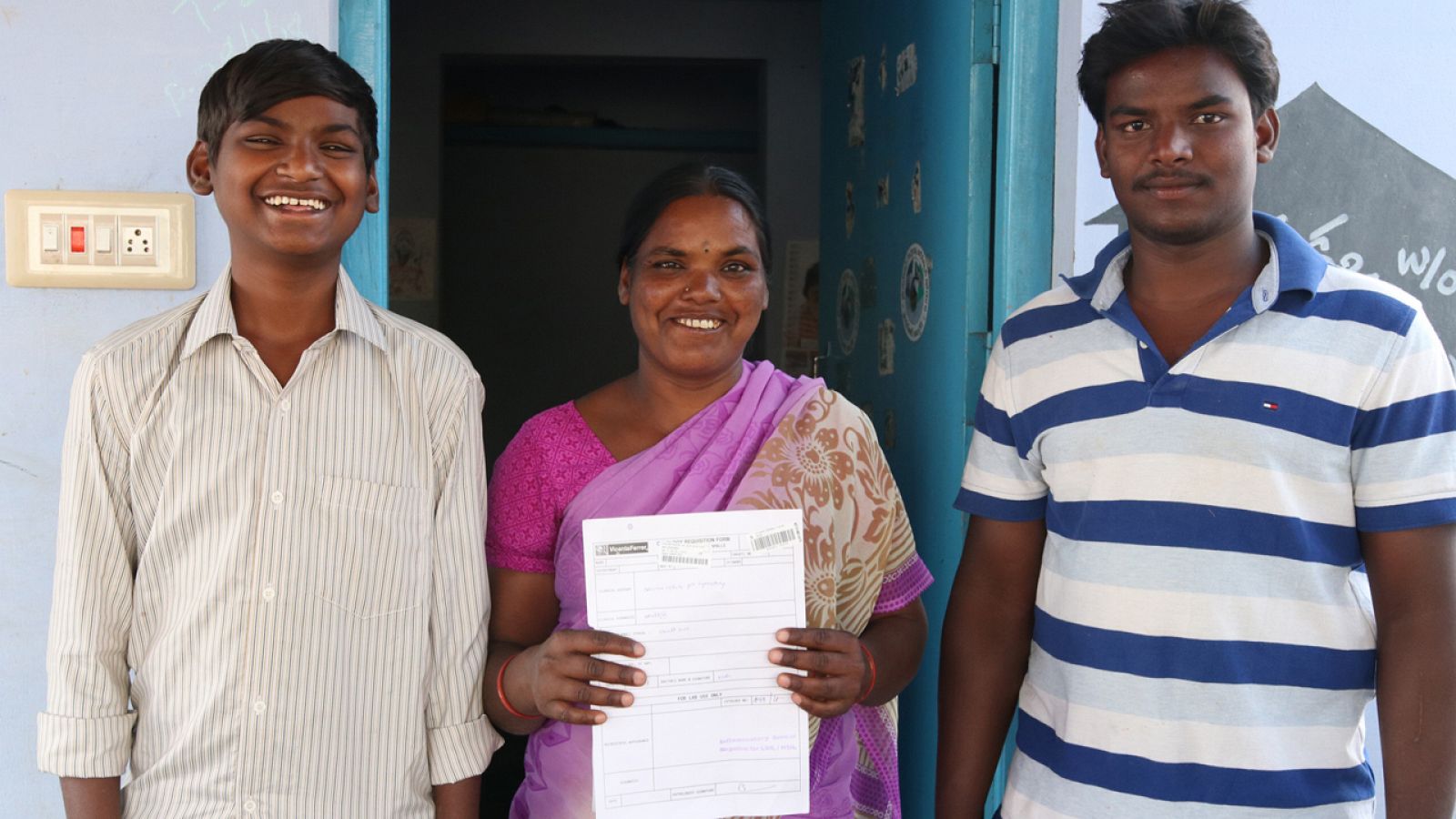 Pedakka posa sonriente con sus informes médicos junto a sus hijos
