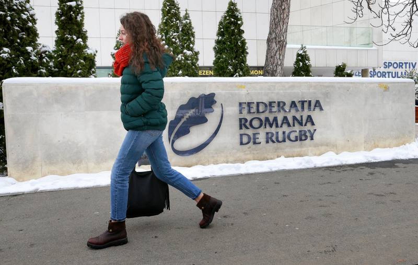 Una mujer camina junto a la entrada de la sede de la Federación Rumana de Rugby, en Bucarest.