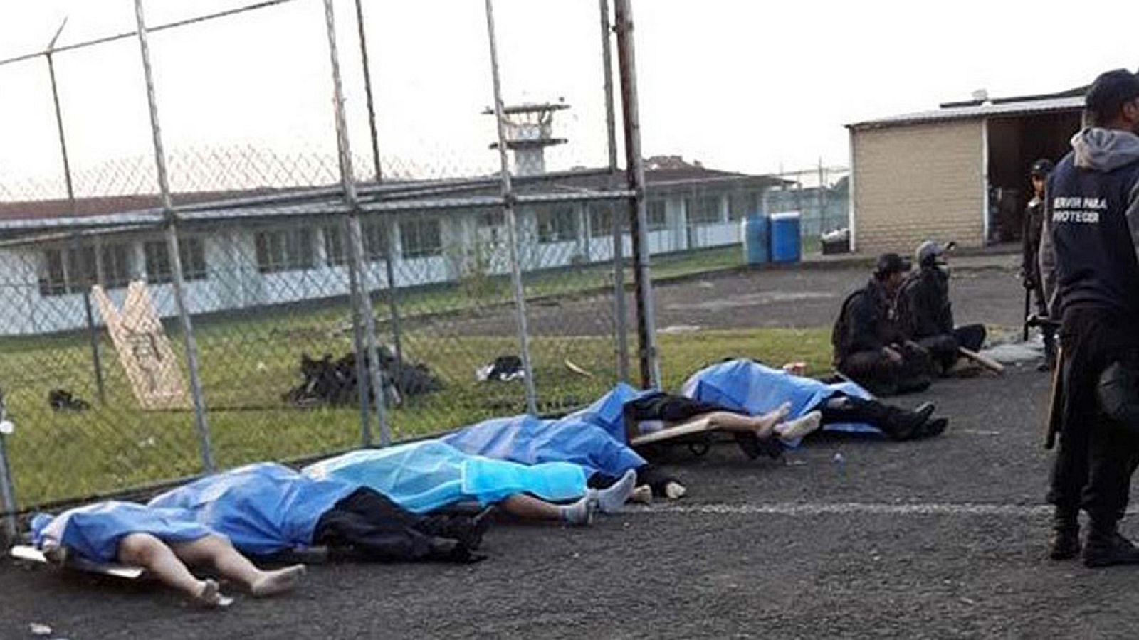 Policías Federales vigilan los cuerpos de fallecidos en el penal La Toma, en el municipio de Amatlán, estado Veracruz