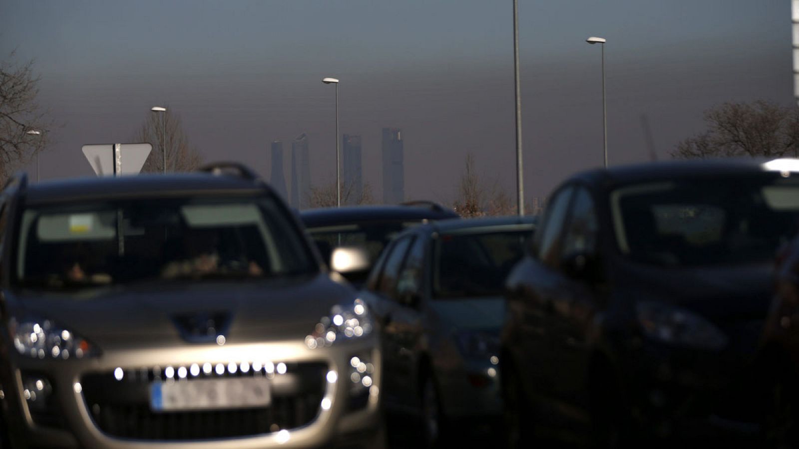 Tráfico en las carreteras que rodean Madrid con el fondo de la nube de contaminación que cubre la capital española