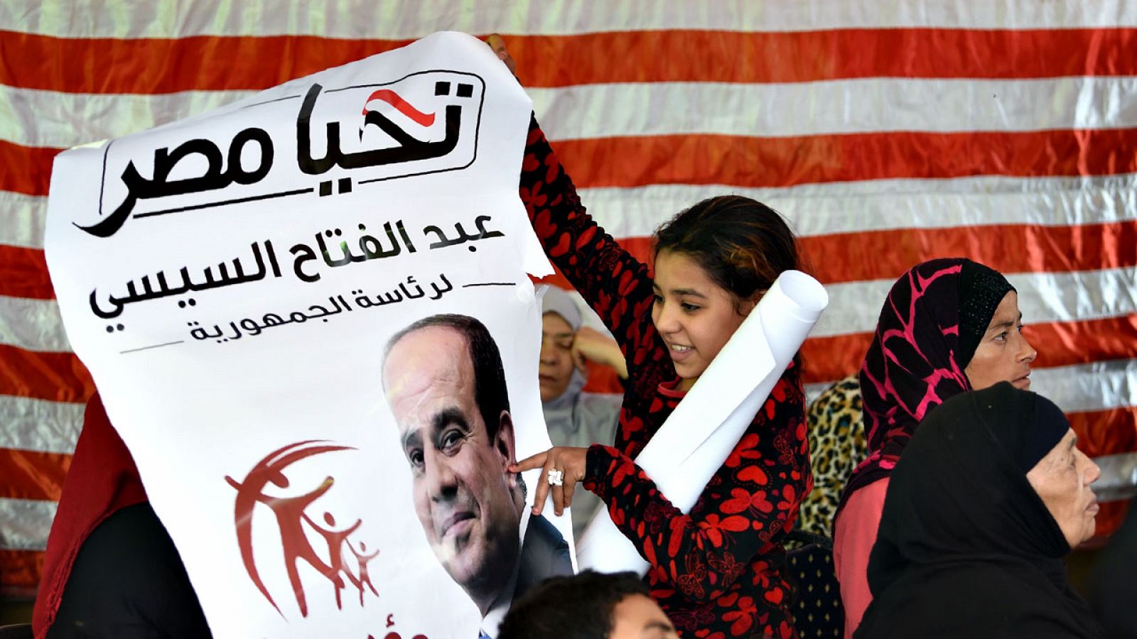 Una niña señala un cartel electoral del presidente egipcio, Abdelfatah al Sisi, en Giza