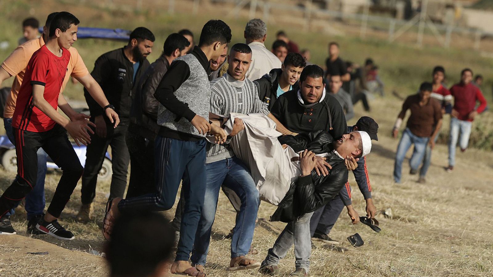 Manifestantes palestinos trasladan a un herido durante las protestas en la frontera entre Gaza e Israel