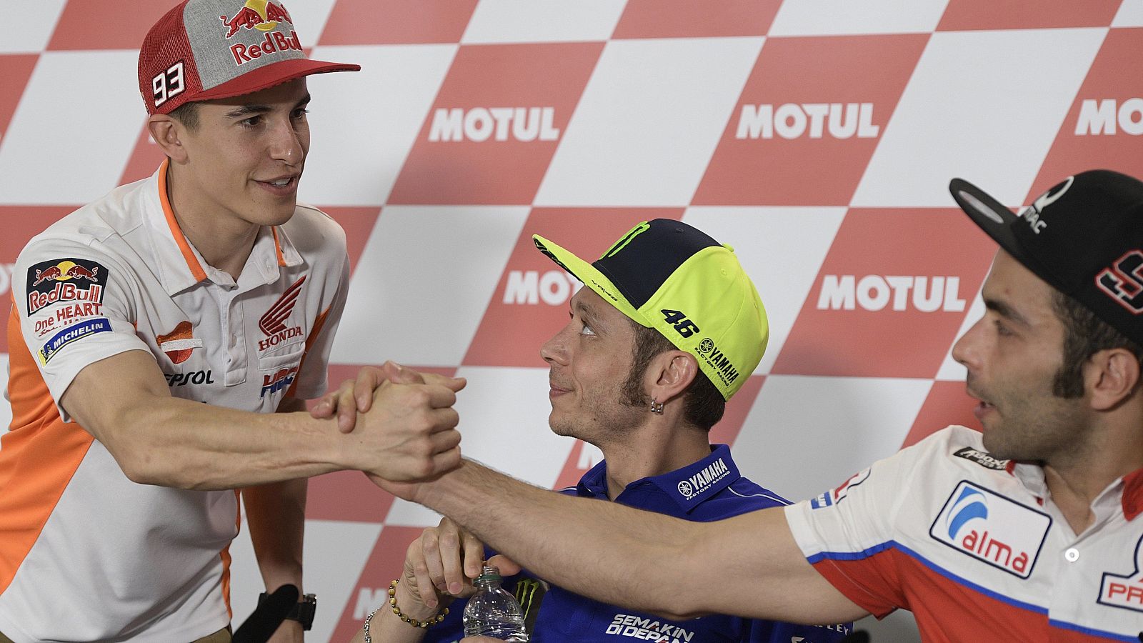 Marc Márquez (i) saluda a Danilo Petrucci (d), ante la mirada de Valentino Rossi (c).