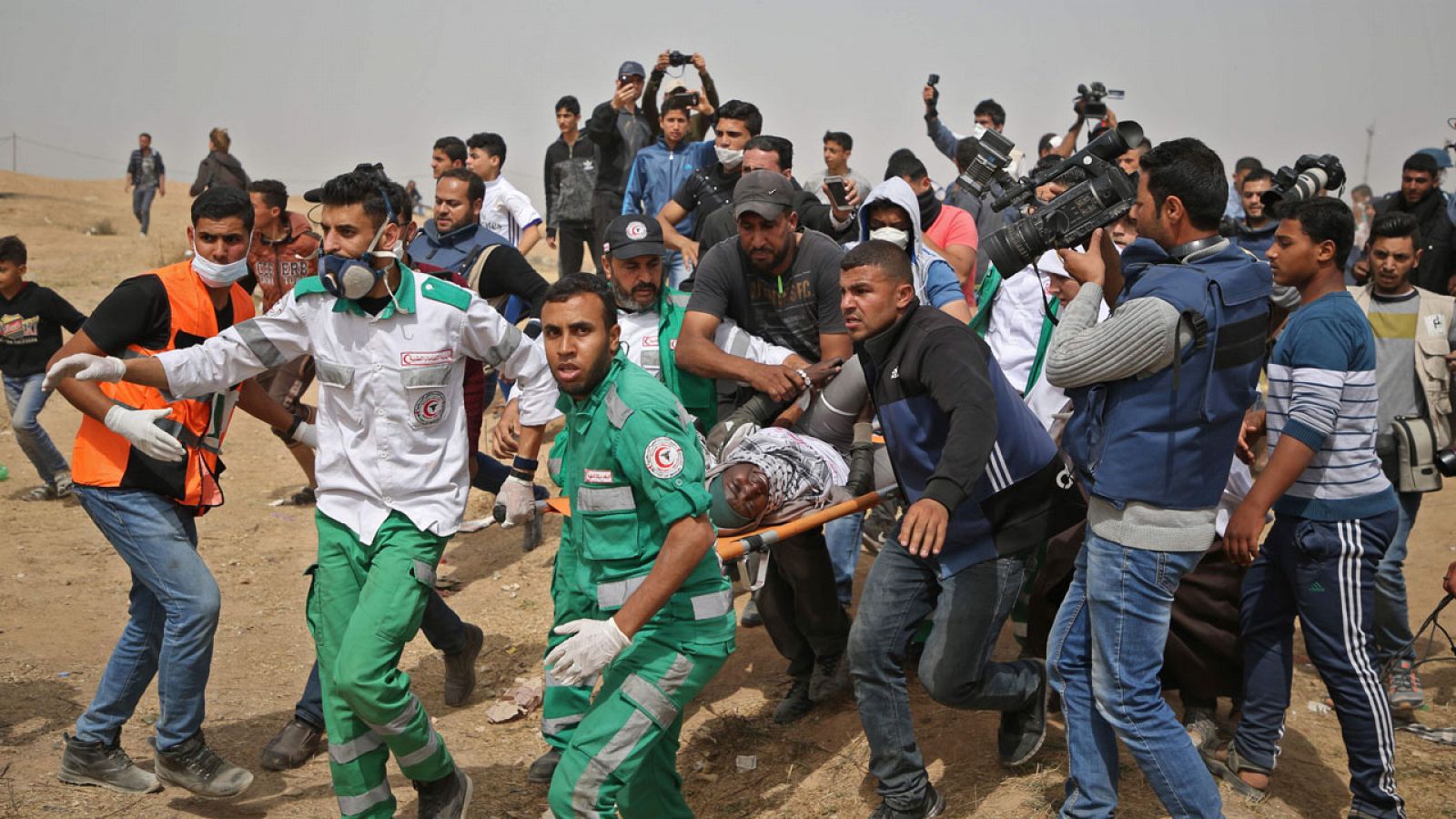 Paramédicos palestinos asisten a una herida durante un enfrentamiento con el Ejército israelí en Gaza