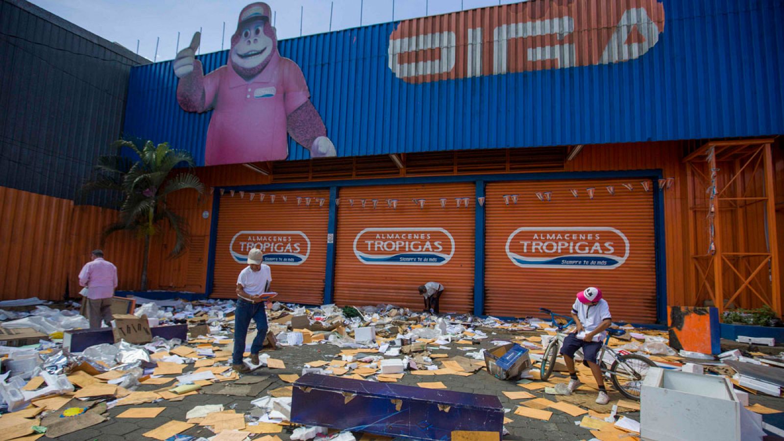 Un grupo de personas recoge objetos dejados por saqueadores en un supermercado de Nicaragua