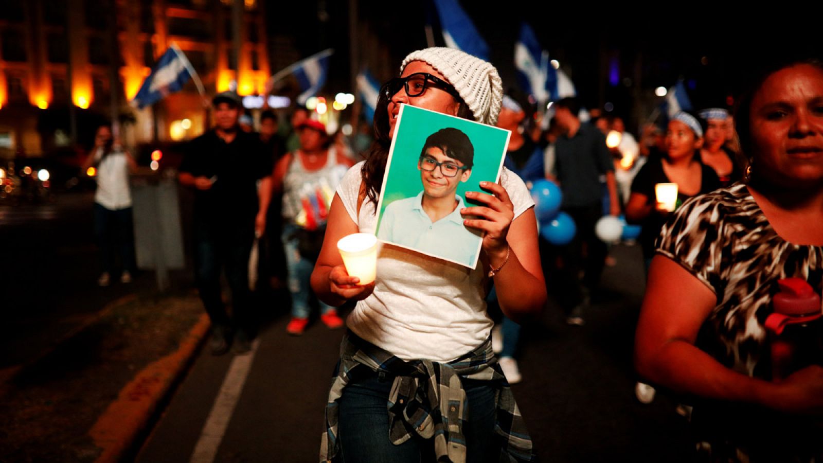 Una mujer sostiene una foto de una de las víctimas durante las protestas en Managua contra Daniel Ortega