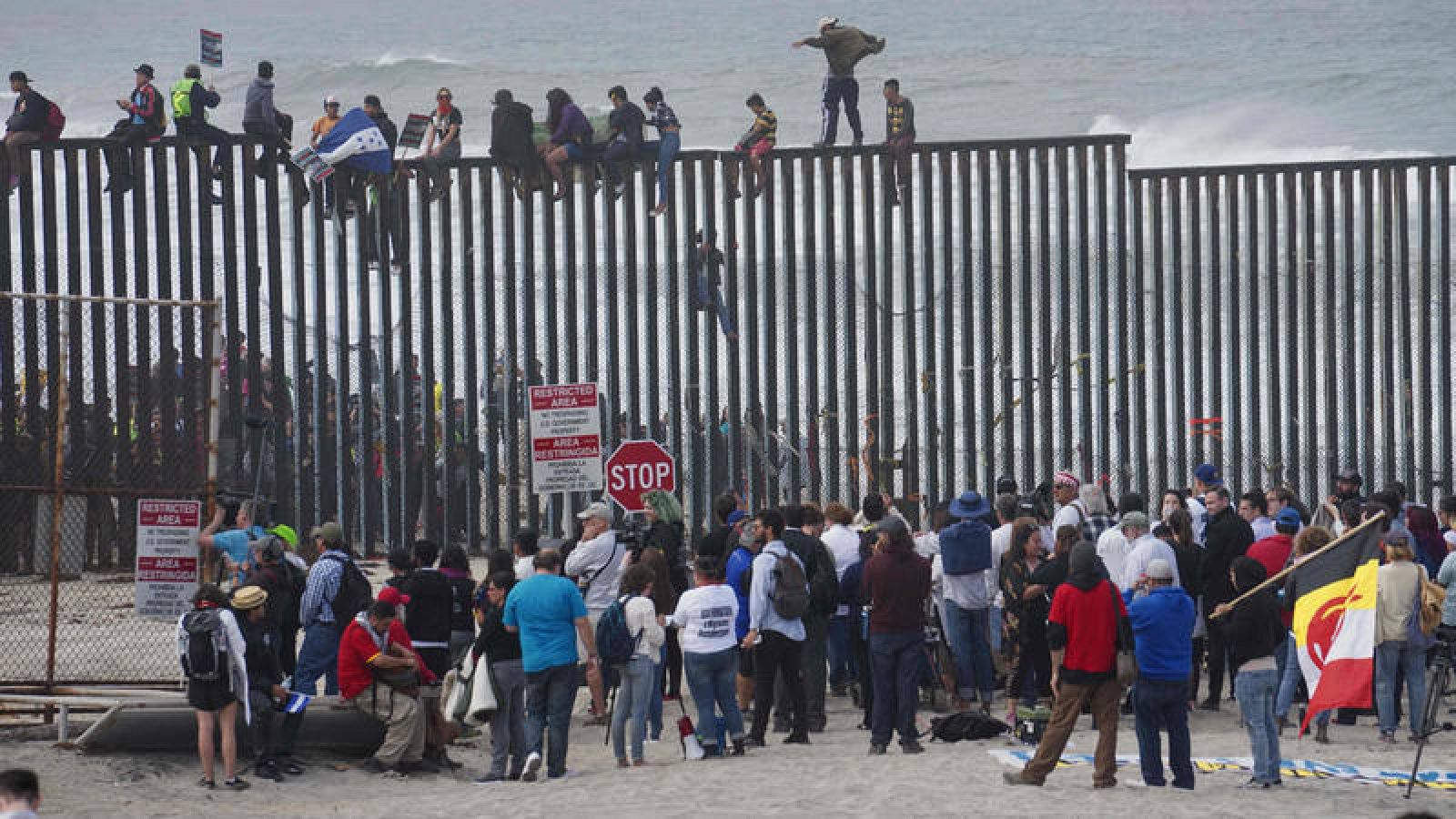 Migrantes centroamericanos escalan la valla fronteriza con EE.UU. en San Isidro, California