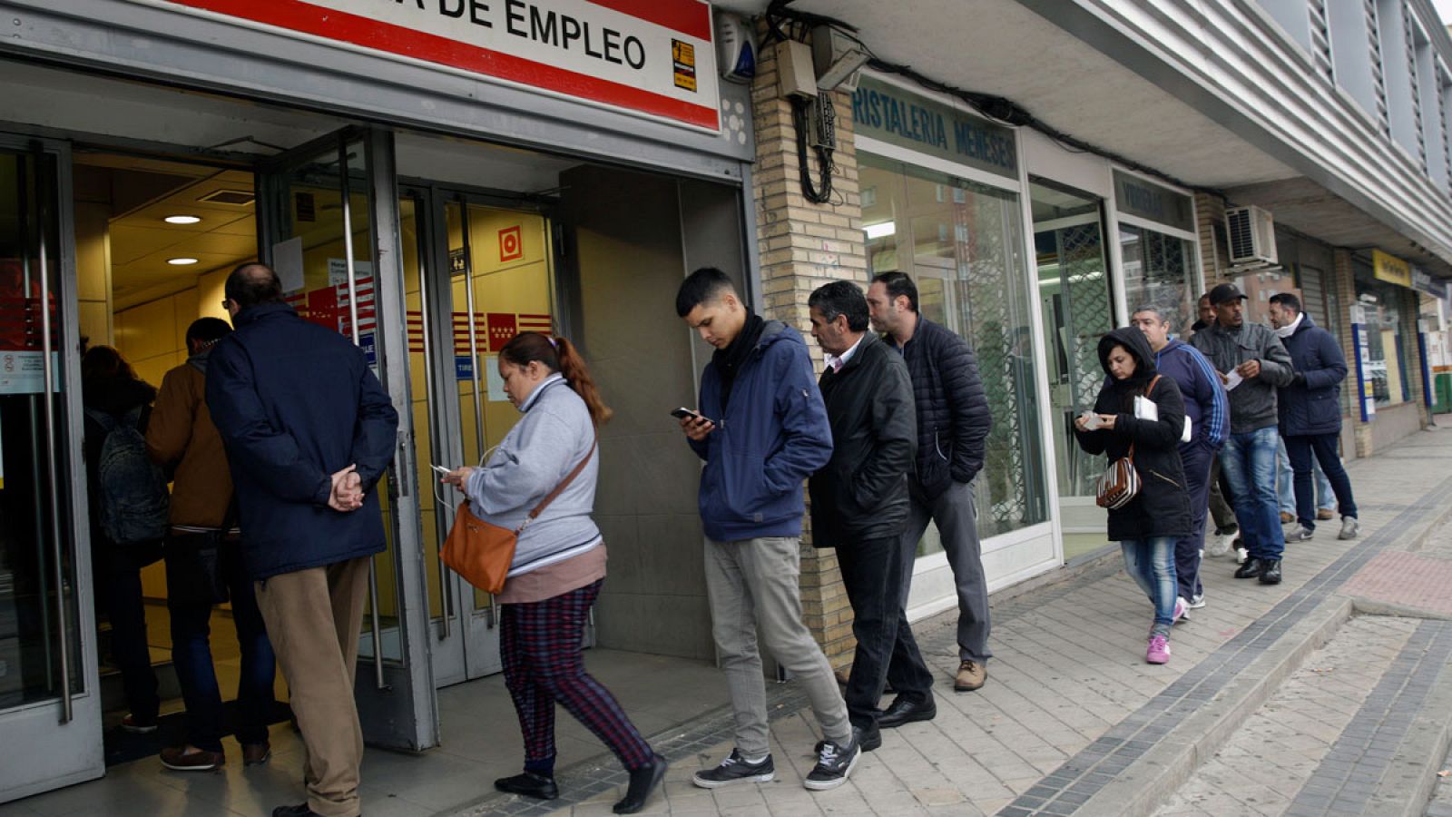 Varias personas esperan para entrar en una oficina de Empleo de la Comunidad de Madrid