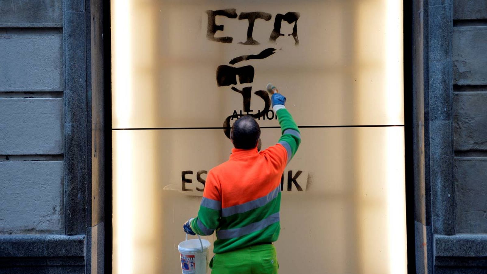 Un operario limpia una pintada en la que se le da las gracias a ETA.