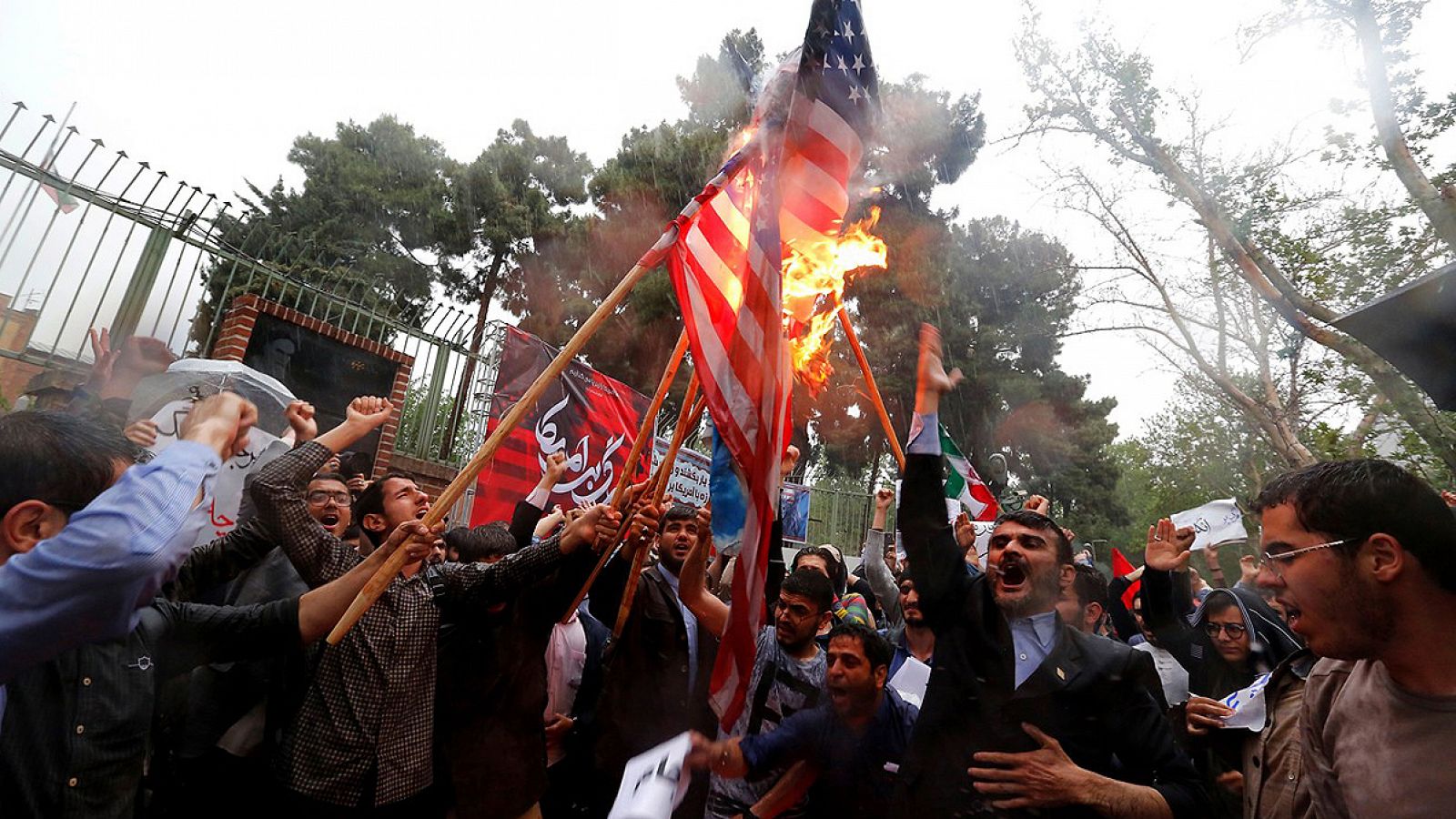 Un grupo de iraníes quema una bandera estadounidense frente a la antigua embajada estadounidense en Teherán
