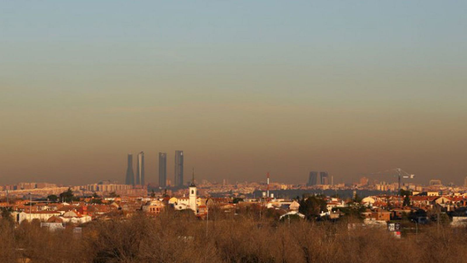 Perfil de la ciudad de Madrid con una nube de contaminación sobre sus edificios