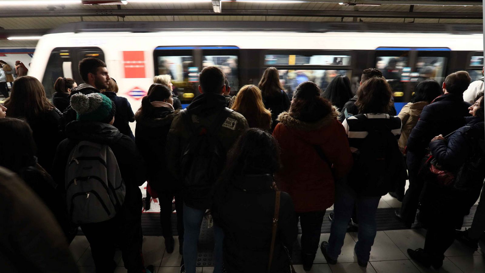 Vista del andén de una estación del metro madrileño, con aglomeración de pasajeros a primera hora de la mañana.