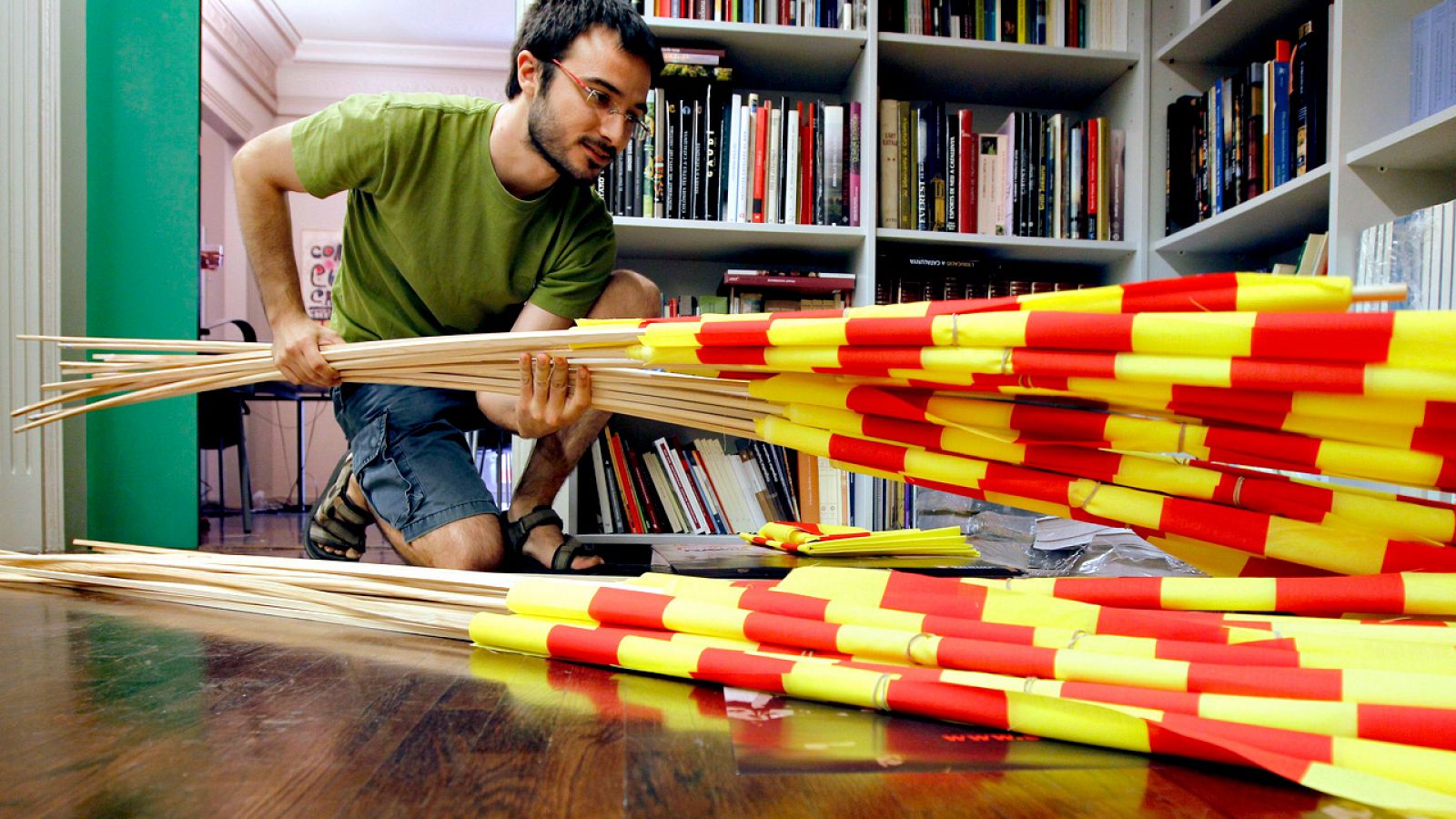 Un miembro de Òmnium Cultural recopila banderas catalanas para una manifestación