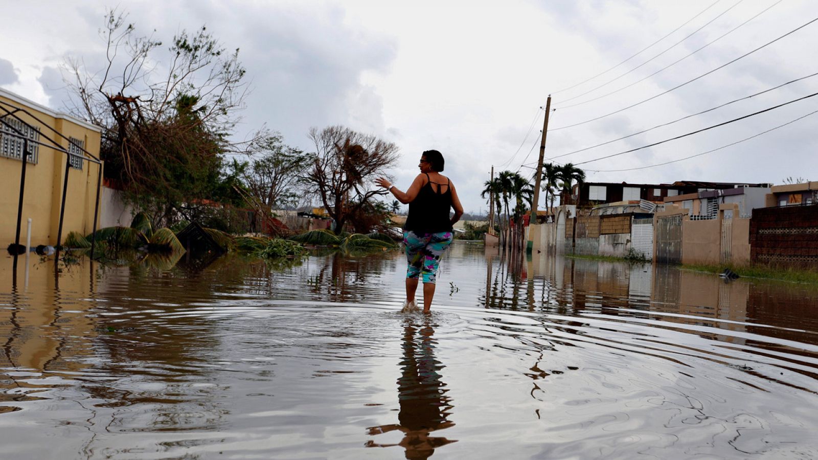 Una mujer cruza una calle inundada en Puerto Rico tras el paso del huracán María
