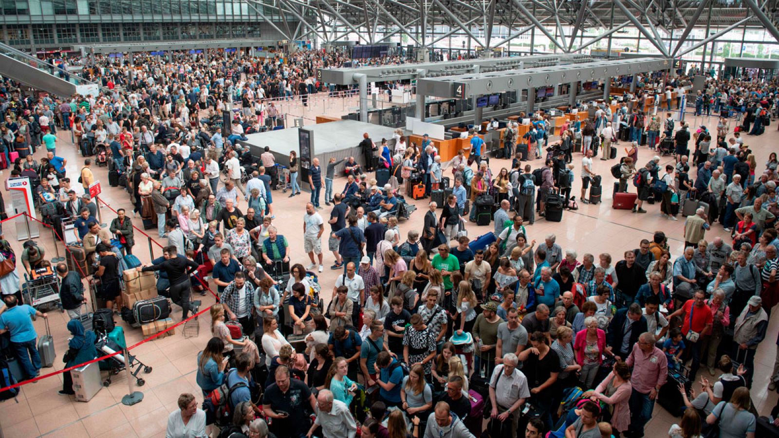 Multitud de pasajeros esperan en el aeropuerto de Hamburgo este domingo