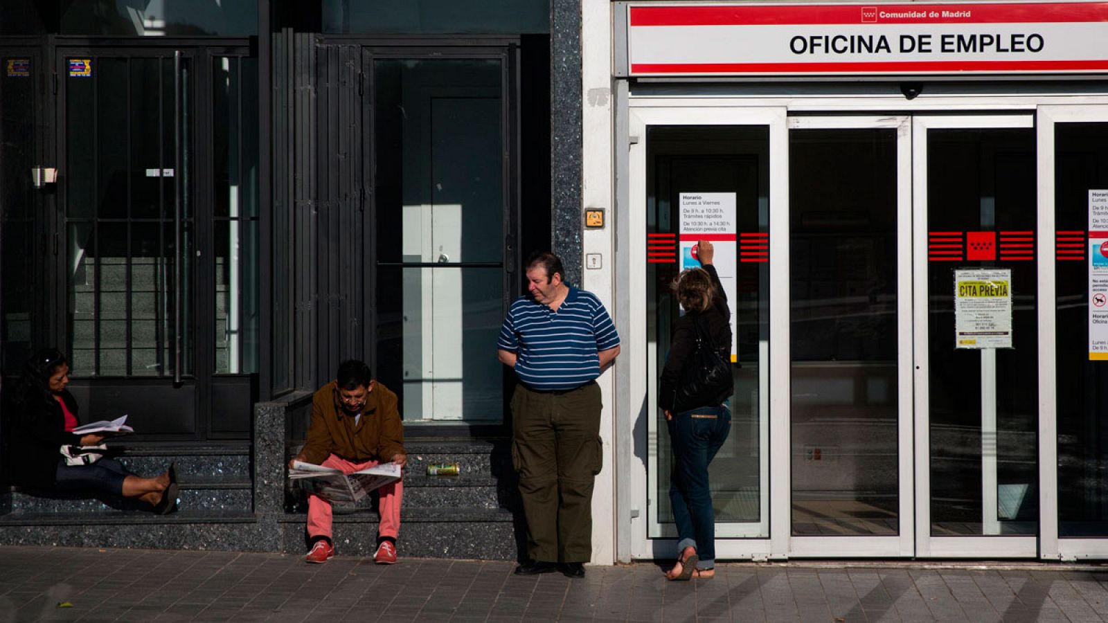 Varias personas esperan a que abra una oficina de empleo en la Comunidad de Madrid