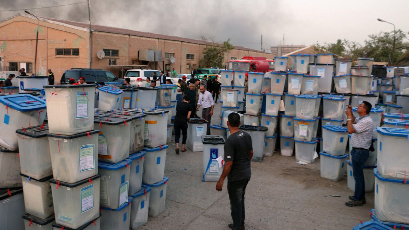 Los bomberos intentan sofocar el incendio en unos almacenes que custodiaban urnas con votos de las elecciones legislativas de mayo