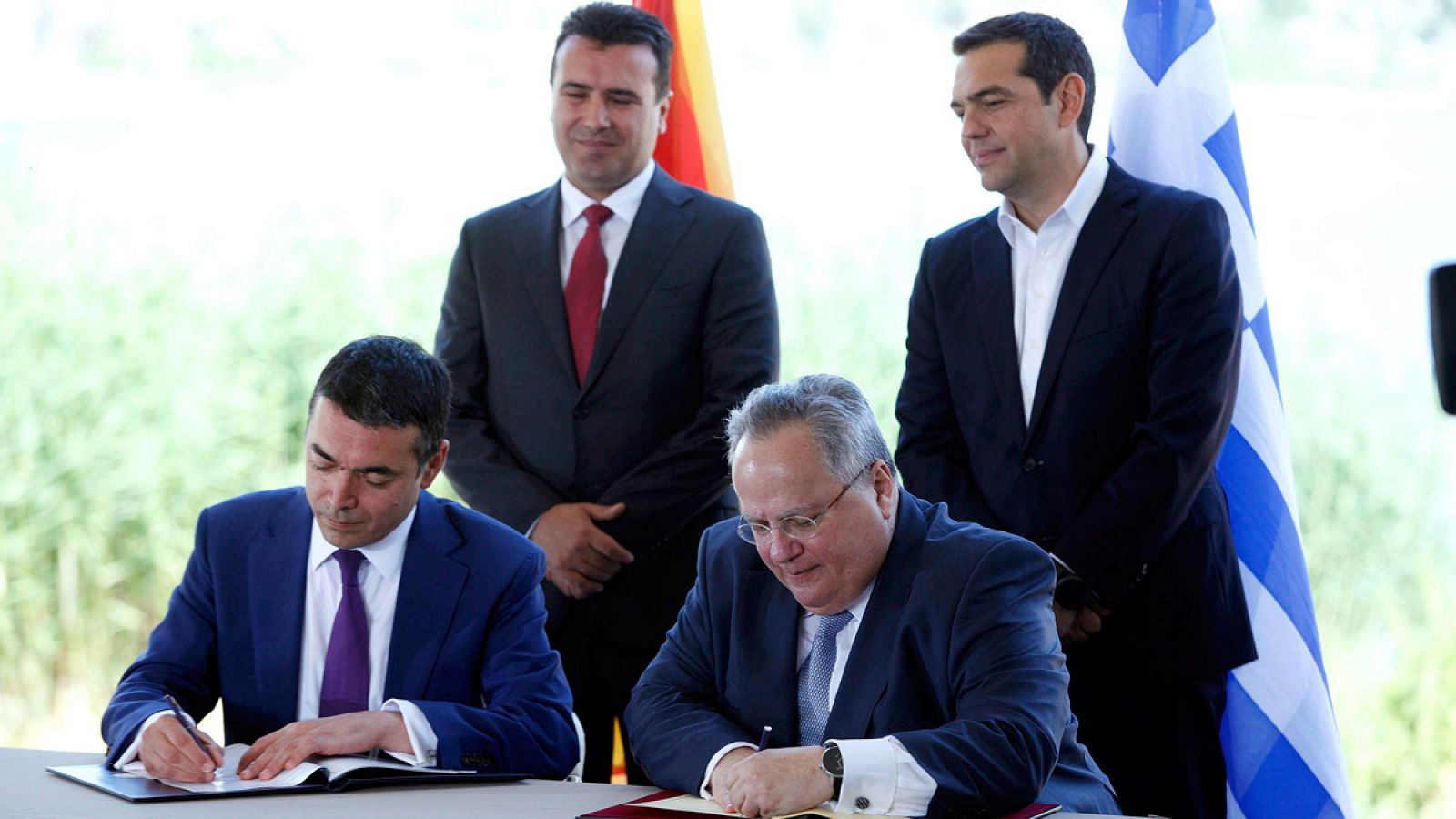 Los ministros de Asuntos Exteriores macedonio, Nikola Dimitrov, y griego, Nikos Kotziás, firman el acuerdo en presencia de los primeros ministros Alexis Tsipras y Zoran Zaev