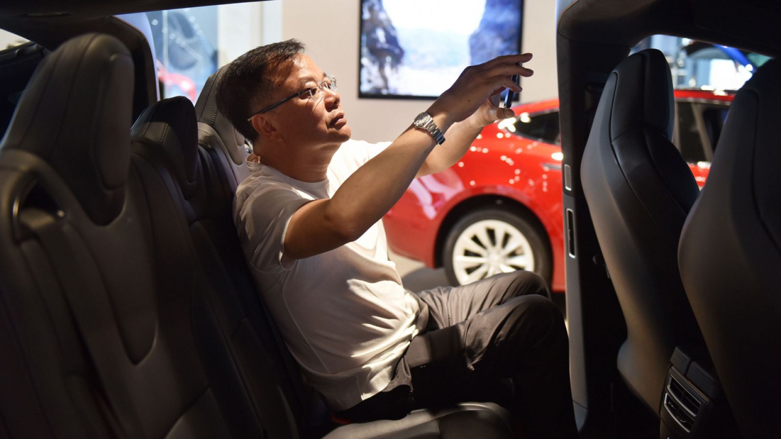 Un hombre fotografía un coche Tesla en Pekín