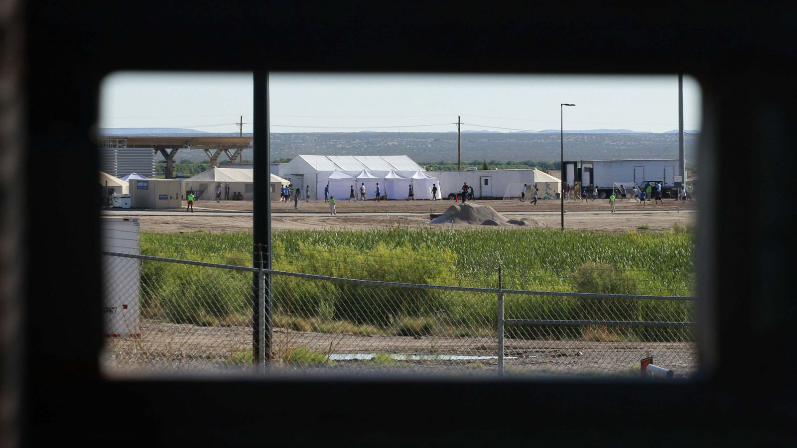 Hijo de migrantes detenidos juegan al fútbol en un campamento cerca de Tomillo, Texas, EE.UU.