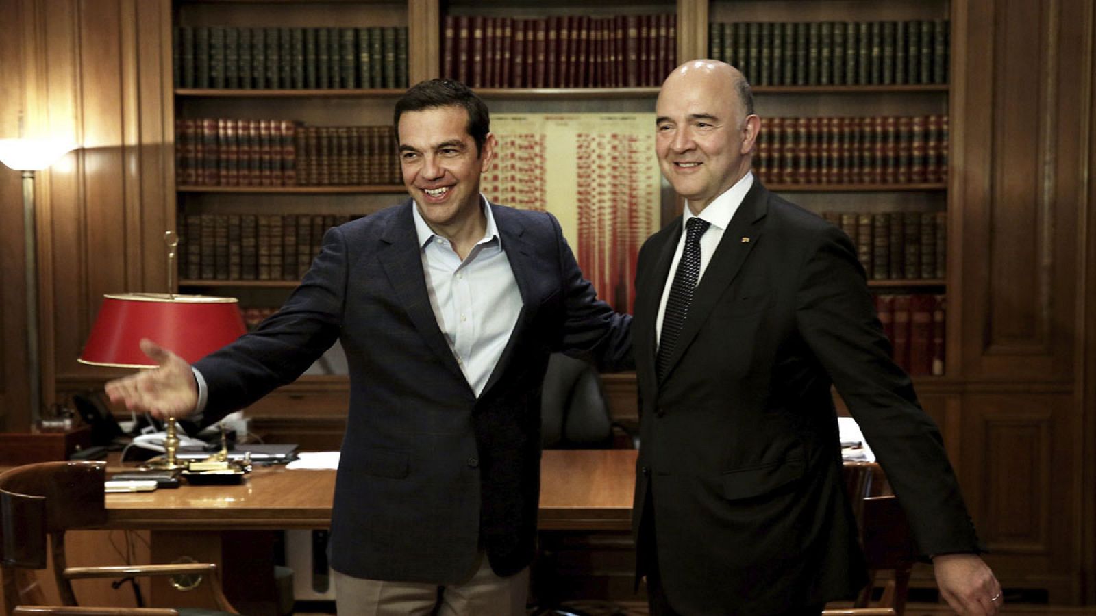 El primer ministro griego, Alexis Tsipras, conversa con el comisario europeo de Asuntos Económicos y Financieros, Pierre Moscovici, durante un encuentro en Atenas
