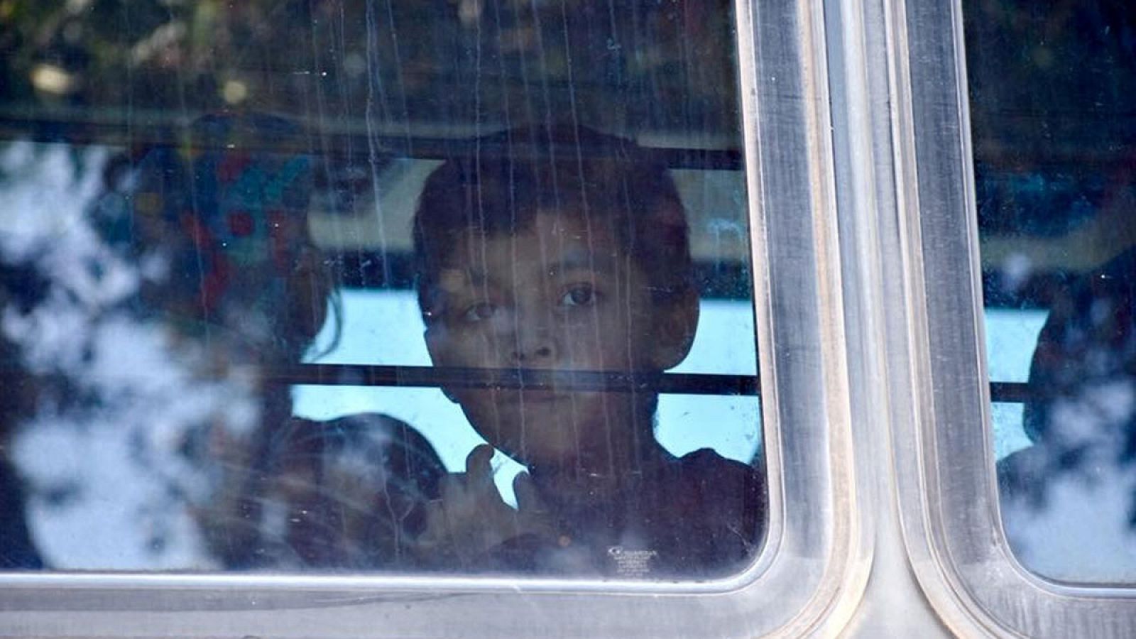 Un niño mirando por la ventana de un autobús que transporta inmigrantes cerca del centro de detención de McAllen, Texas (EE.UU.).