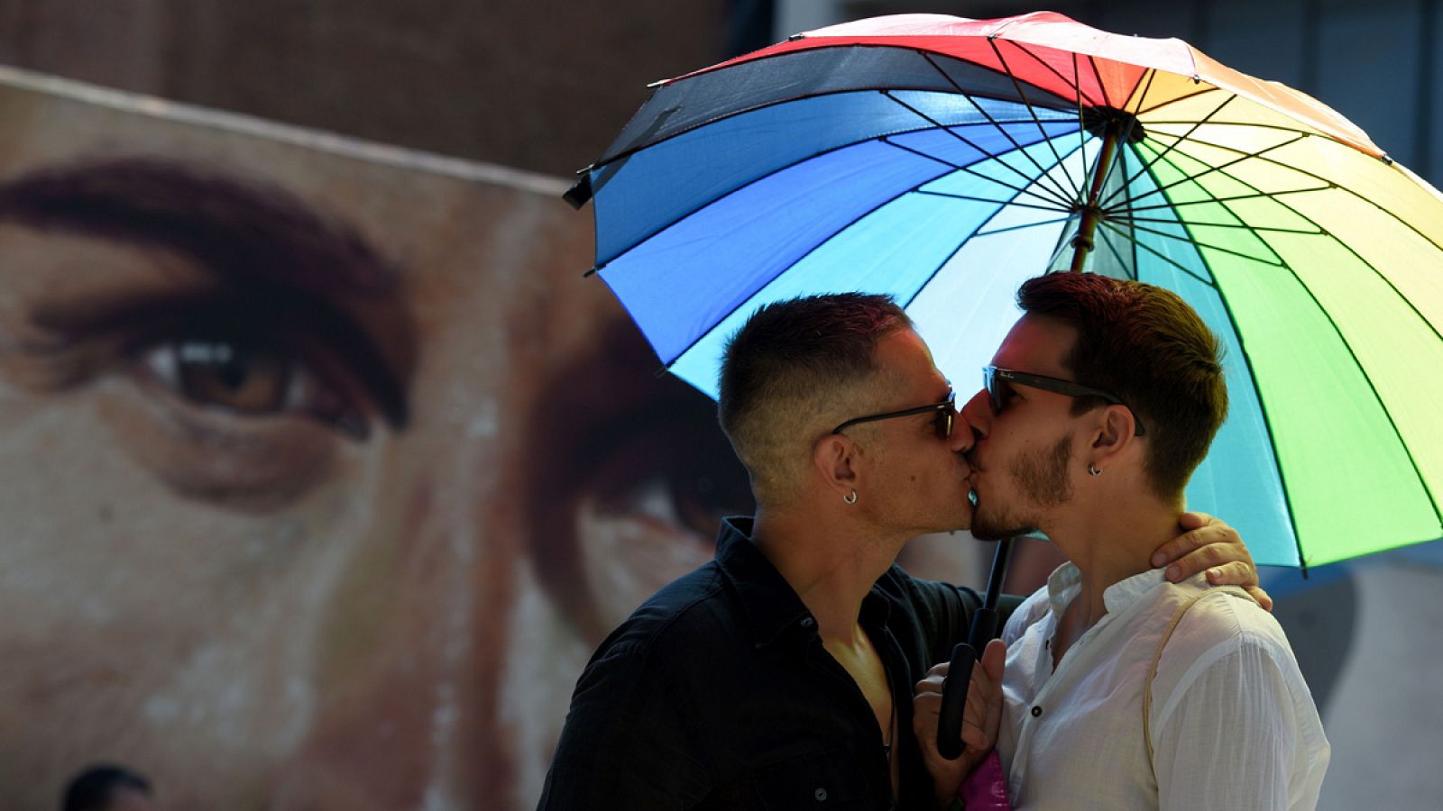 Una pareja se besa durante la marcha del Orgullo de Barcelona