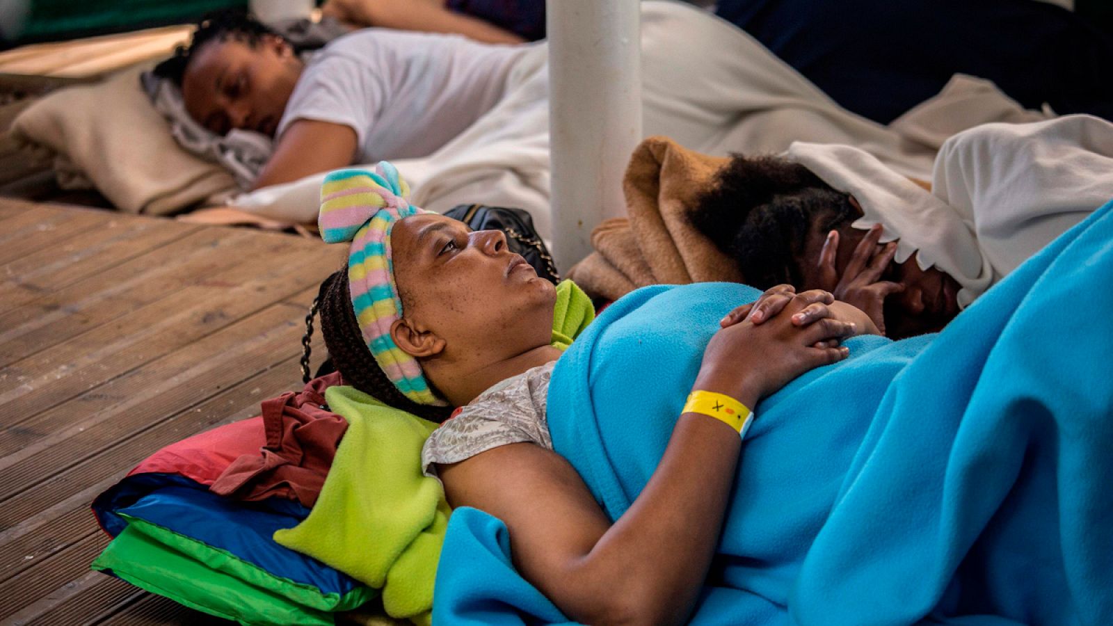 Una madre descansa junto a su hija en la cubierta de la embarcación de rescate Open Arms.