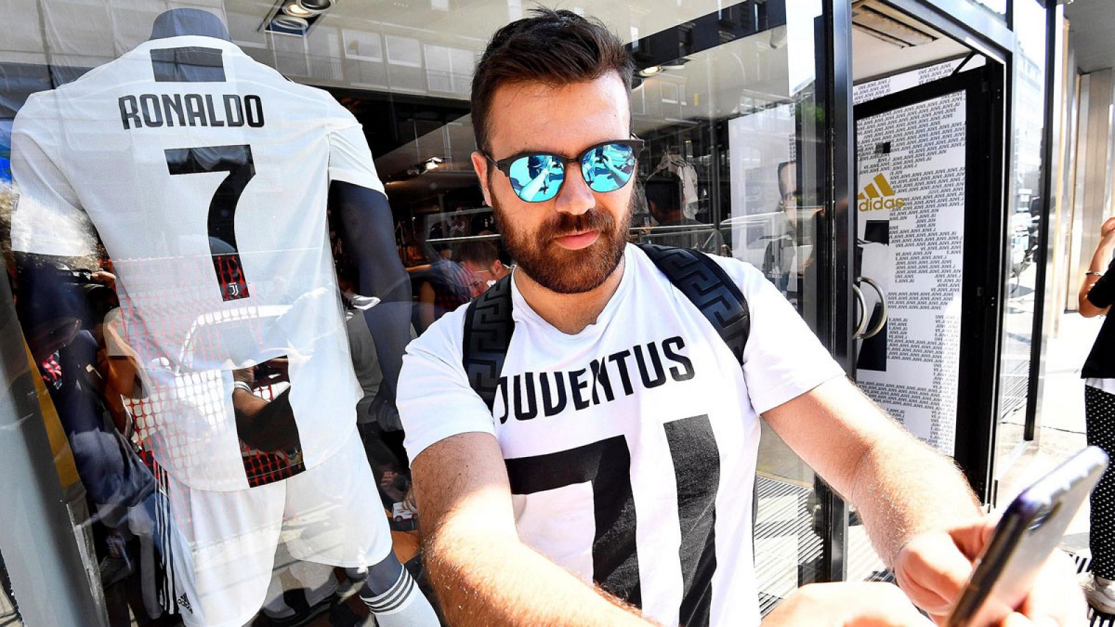 Un aficionado se hace un 'selfie' junto a la nueva camiseta de Cristiano Ronaldo de la Juventus