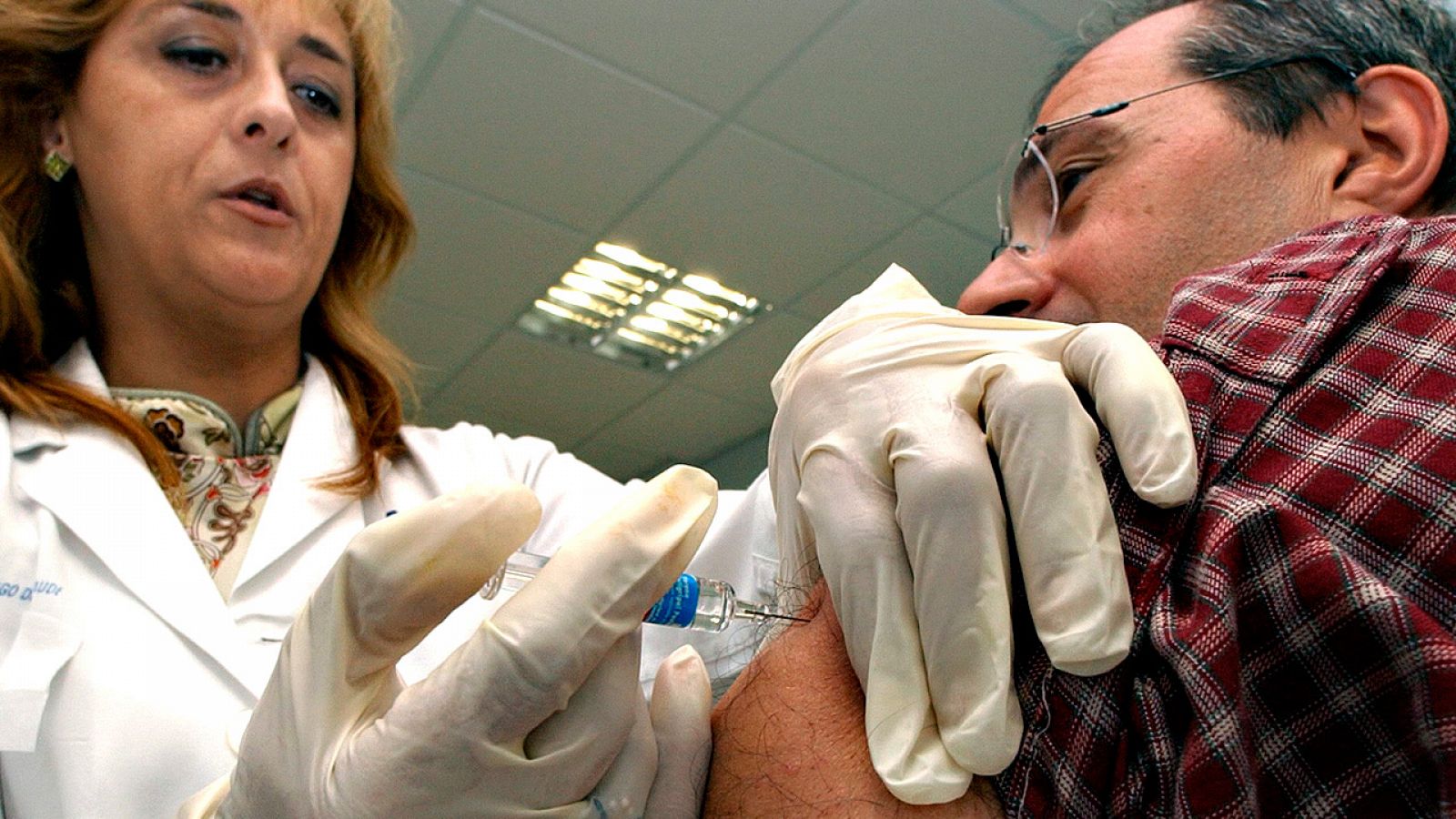 Una enfermera administra una vacuna a un paciente
