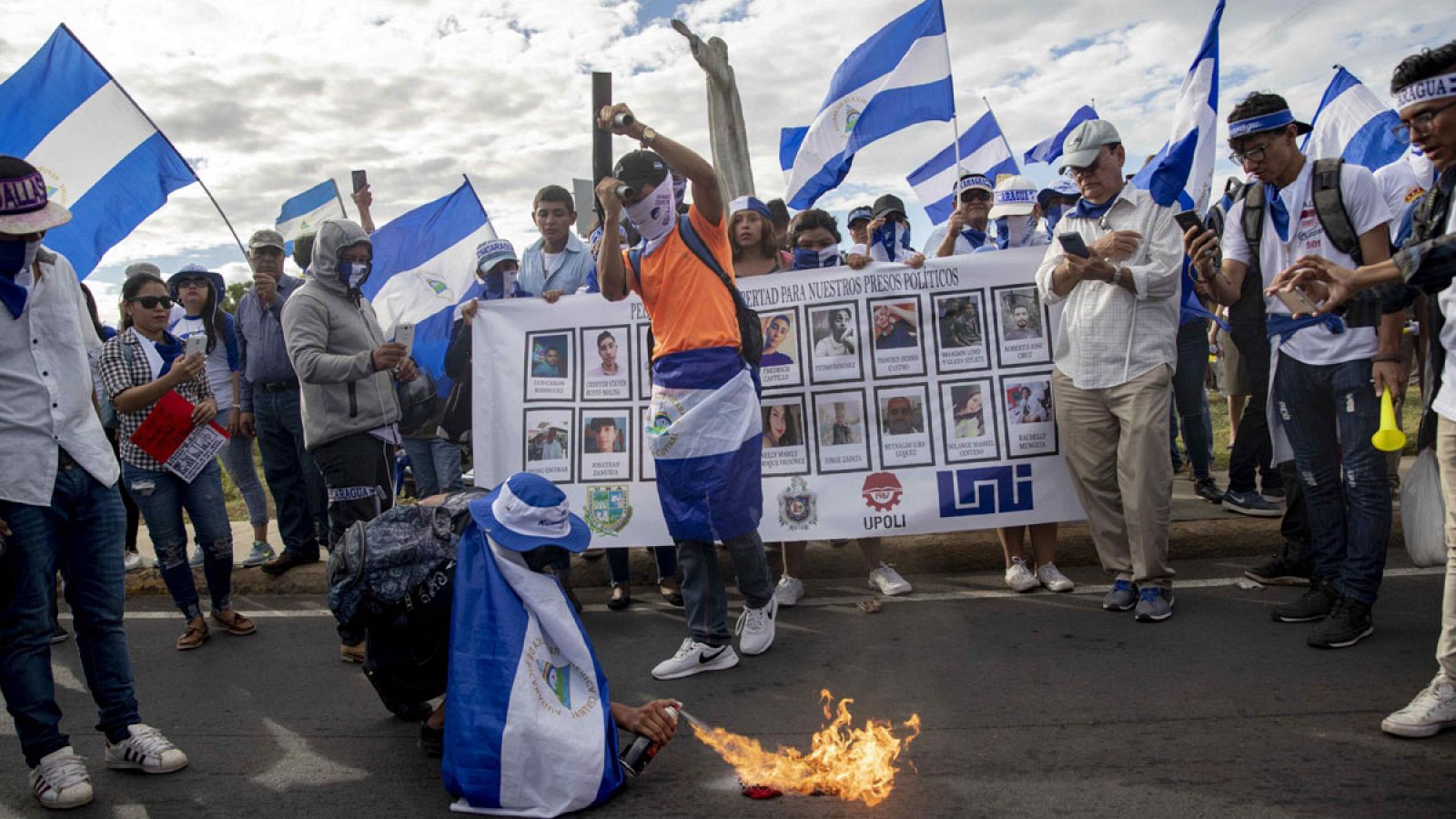 Un joven quema una bandera del partido Frente Sandinista Liberación Nacional (FSLN) durante la marcha denominada "Nada está normal" el sábado 18 de agosto de 2018, en Managua (Nicaragua).