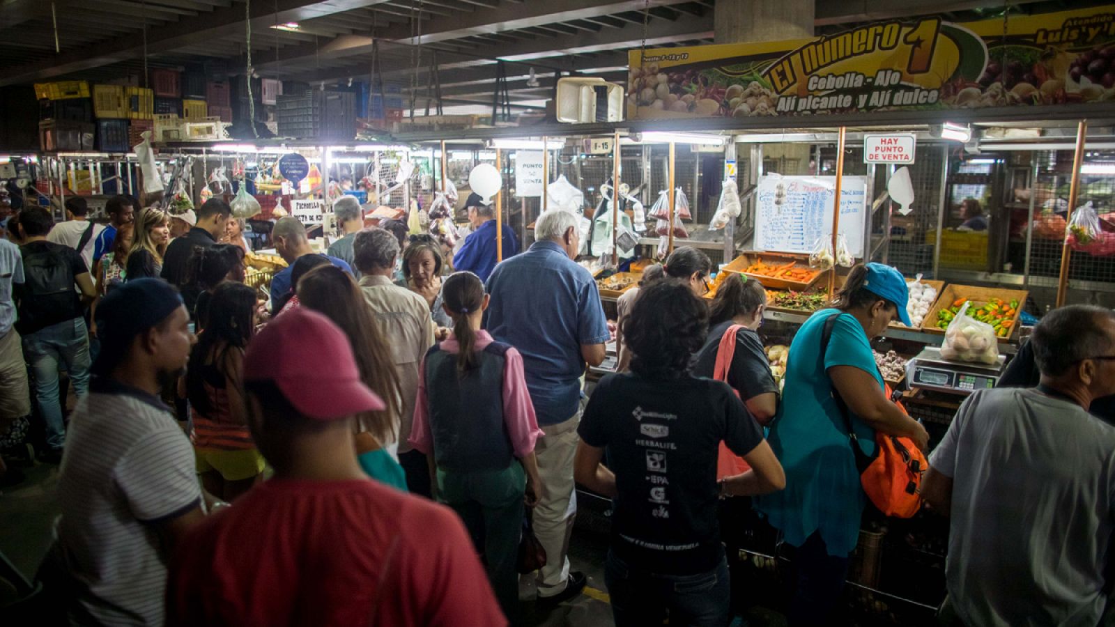 Venezolanos compran alimentos en un mercado municipal