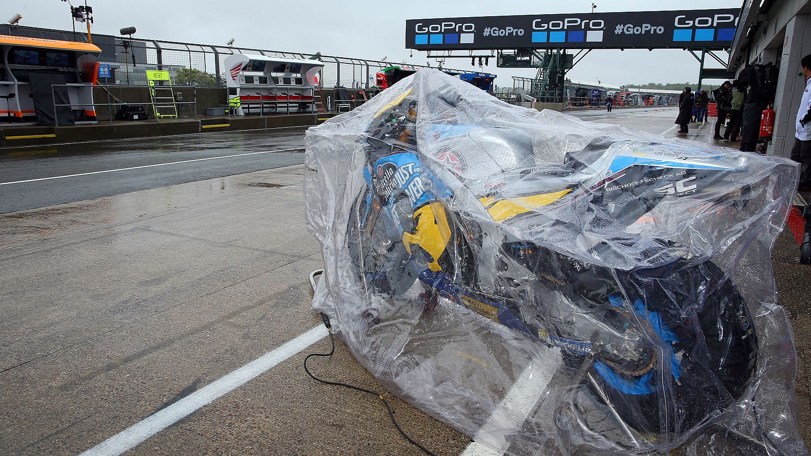 Una moto aguarda en el box de Silverstone, protegida por un plástico por la lluvia.