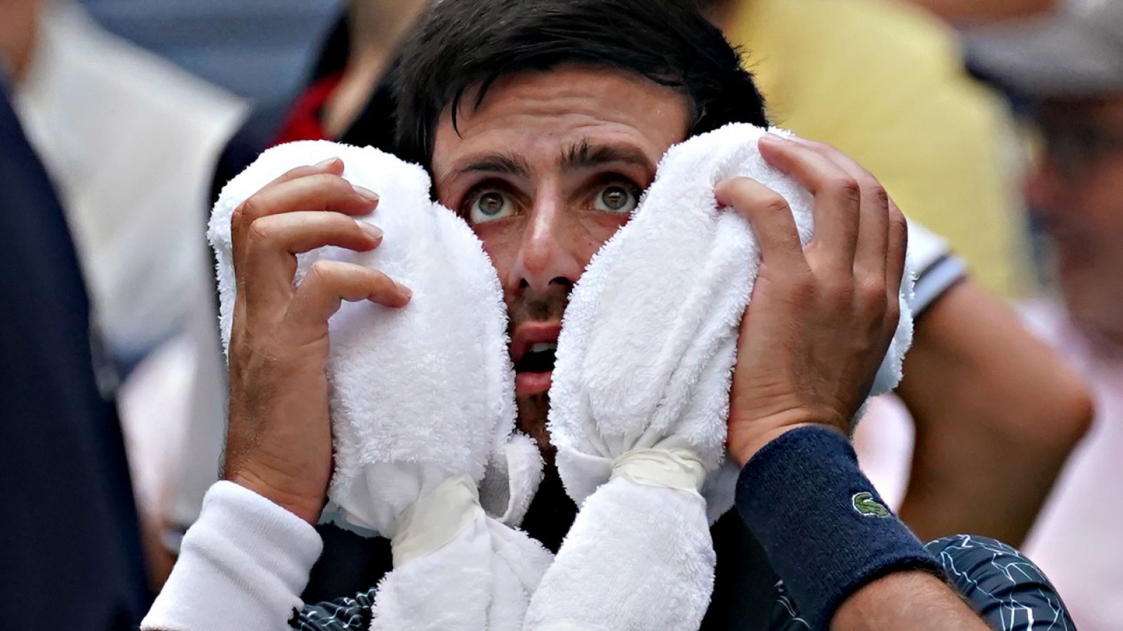 Novak Djokovic trata de aliviar con dos toallas humedas el sofocante calor que caía sobre Flushing Meadows en una pausa de su partido contra Marton Fucsovics