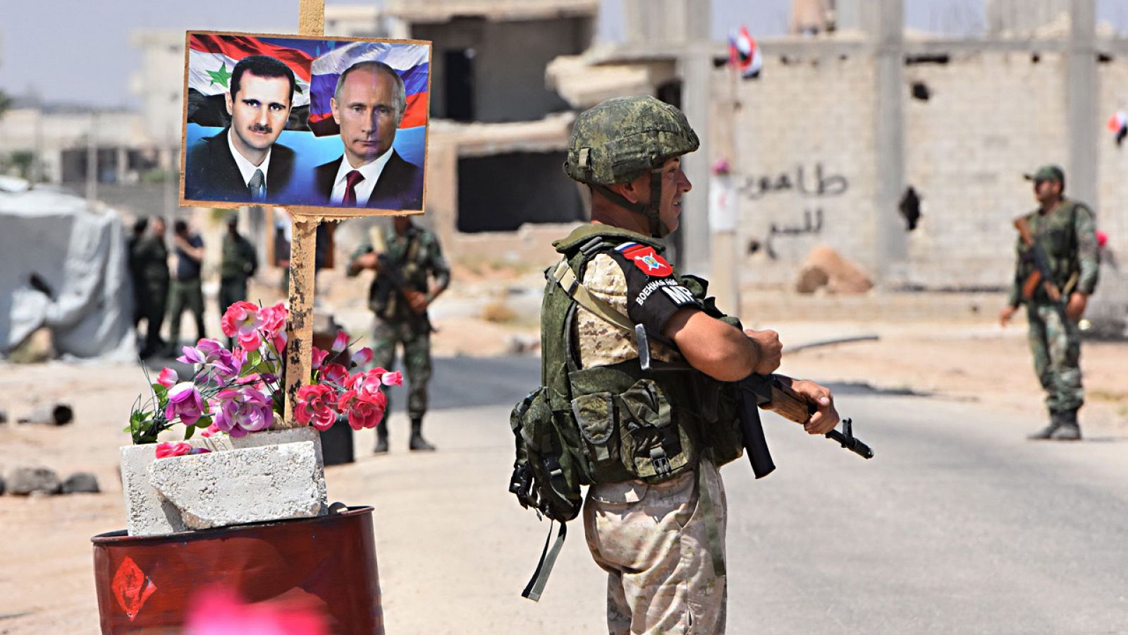 Soldados sirios custodian un paso cerca de Idleb, adornado con un retrato doble de Bachar al Asad y Vladímir Putin