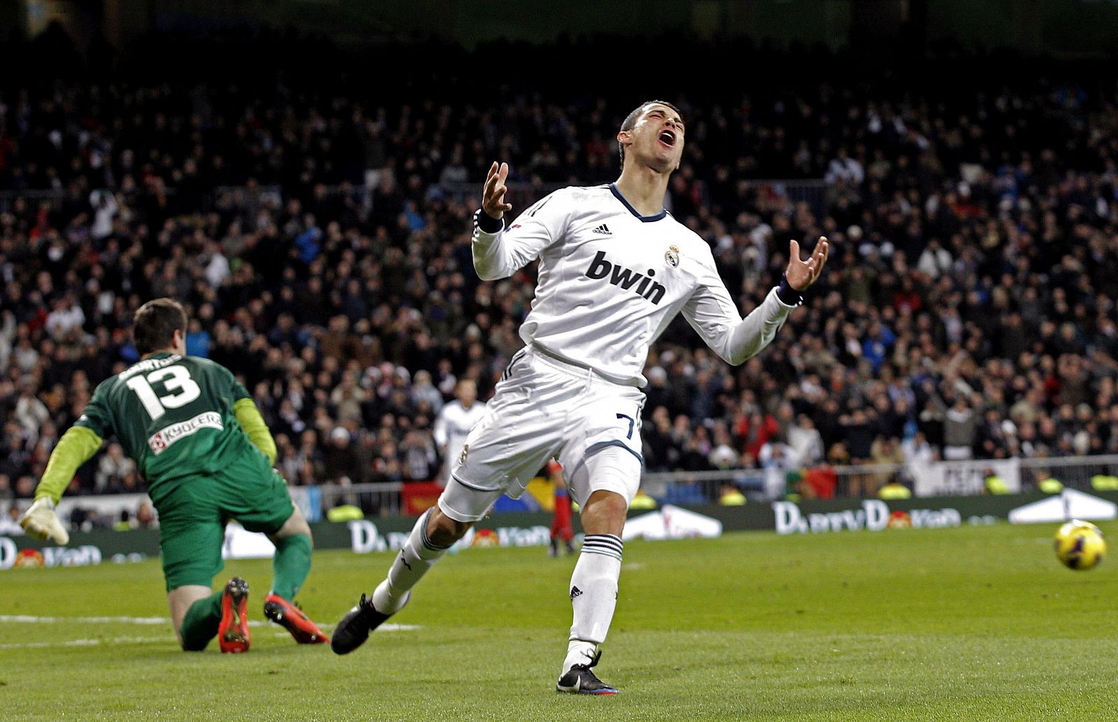 El delantero portugués del Real Madrid, Cristiano Ronaldo (d), se lamenta de una ocasión fallada en presencia del portero belga del Atlético de Madrid, Thibaut Courtois, en un partido de 2012