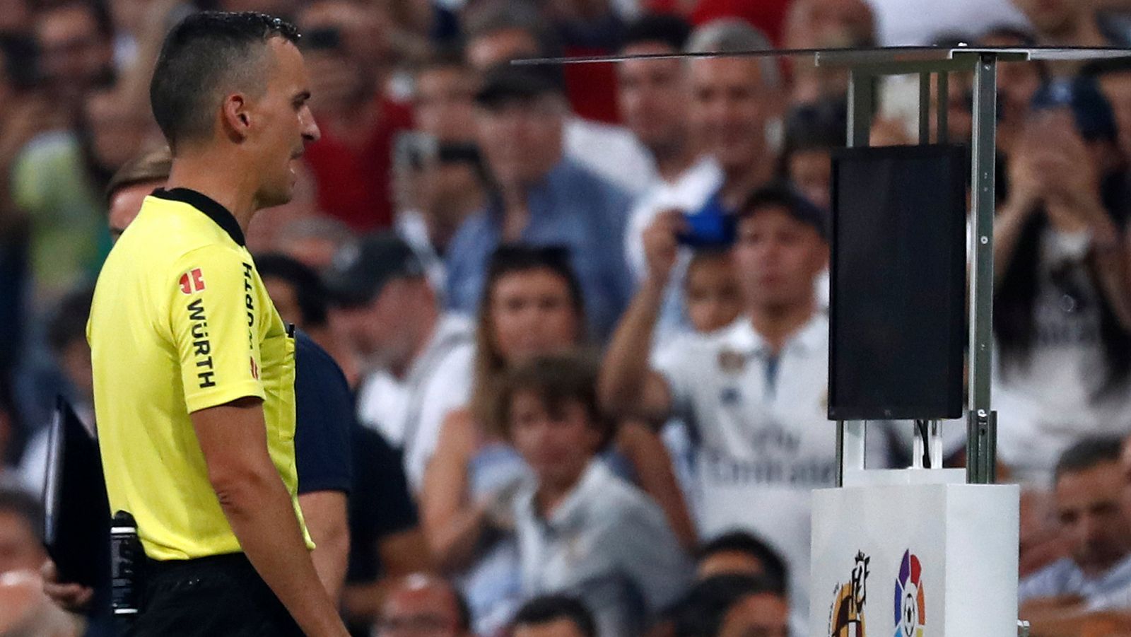 El árbitro Jaime Latre consulta el VAR en el Bernabéu.