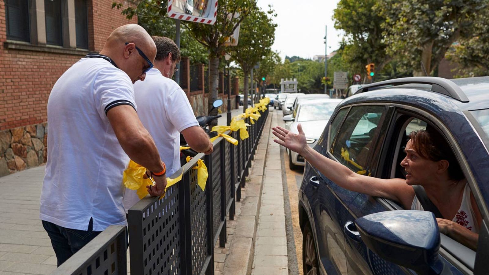 Una mujer increpa a quienes retiran lazos amarillos de la vía pública.