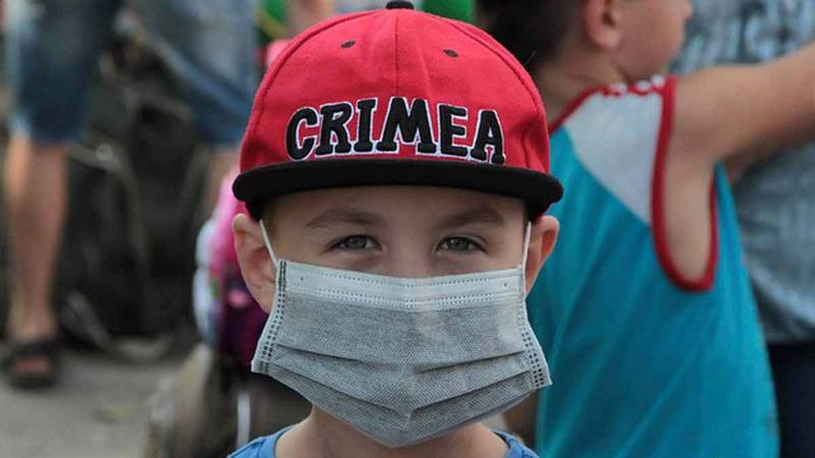 Niño se protege con una máscara de la contaminación
