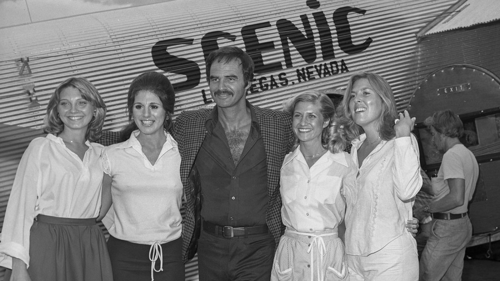 Fotografía del 3 de agosto de 1978 cedida por Las Vegas News Bureau donde se ve a Burt Reynolds (c) posando durante el rodaje del programa de televisión 'Hello Kaye Ballard' en el Aeropuerto Internacional McCarran en Las Vegas, Nevada (EE.UU.)