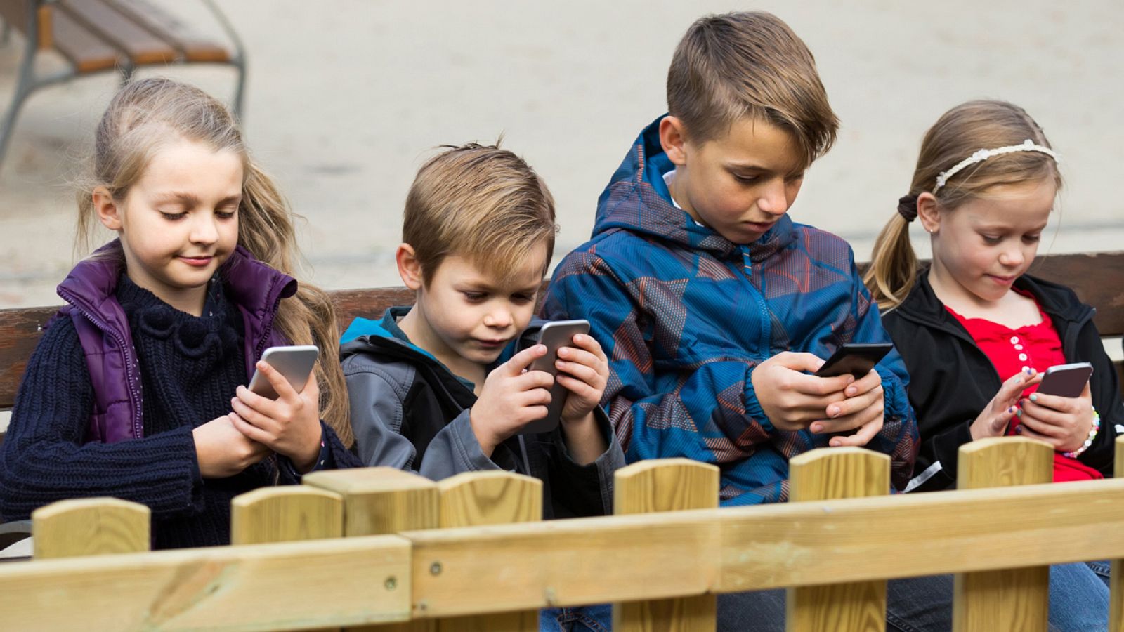 Un grupo de niños utiliza su teléfono móvil