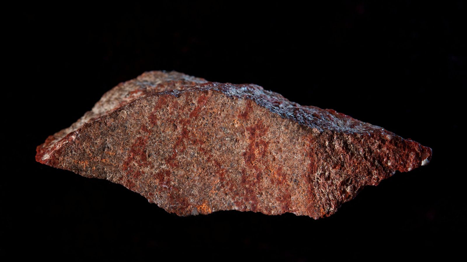 la roca con los dibujos de un lápiz de ocre hallada en la cueva Blombos, Sudáfrica